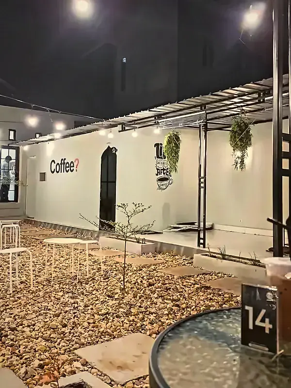 Area outdoor Eloka Pomalaa dengan lampu gantung dan tanaman